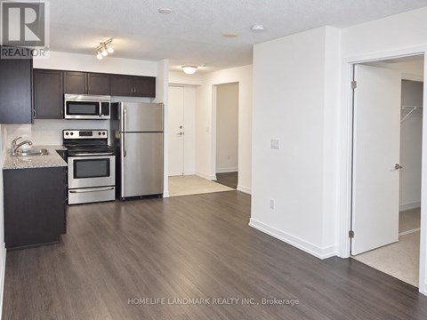 A kitchen with a black counter top and stainless steel appliances.