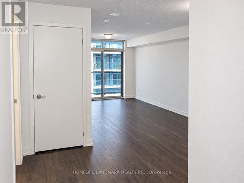 A room with a white door and wooden flooring.