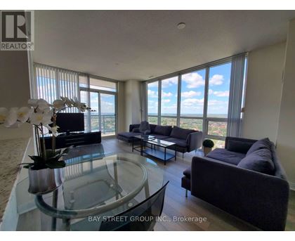 A living room with a glass table and a view of the ocean.