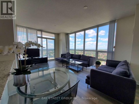 A living room with a glass table and a view of the ocean.