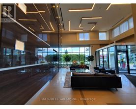 A modern office space with a long black couch and a large window.