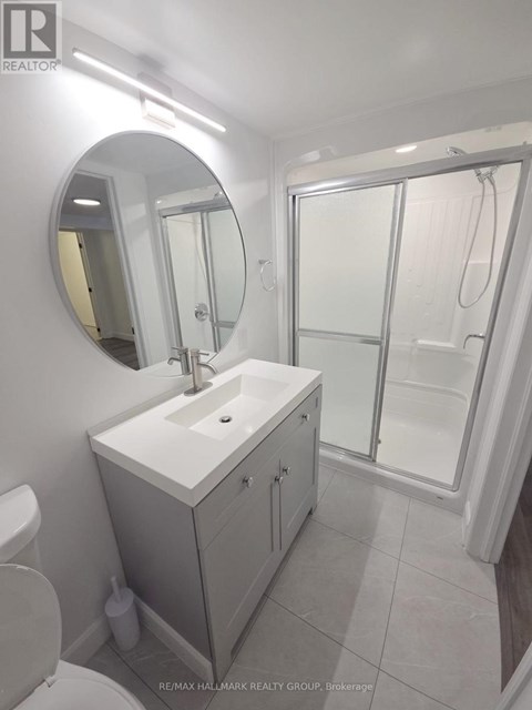 A bathroom with a sink, mirror, and toilet.