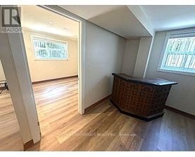 A room with wooden flooring and a window with blinds.