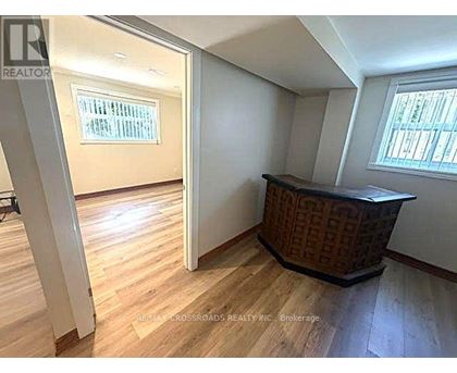 A room with wooden flooring and a window with blinds.