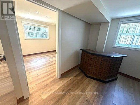 A room with wooden flooring and a window with blinds.