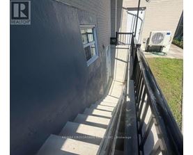 A concrete staircase leading to a door with a window.