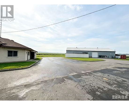 A real estate image of a property with a building and a driveway.