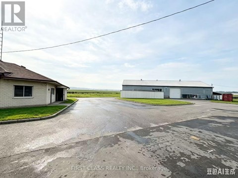 A real estate image of a property with a building and a driveway.
