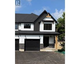 A modern house with a black and white exterior and a brick chimney.