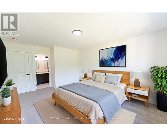 A bedroom with a bed, nightstand, and a painting on the wall.