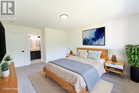 A bedroom with a bed, nightstand, and a painting on the wall.