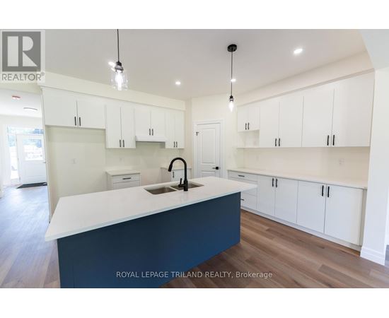 A kitchen with white cabinets and a dark blue island.