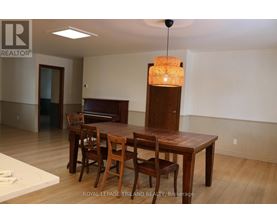 A dining room with a wooden table and chairs.