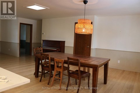 A dining room with a wooden table and chairs.