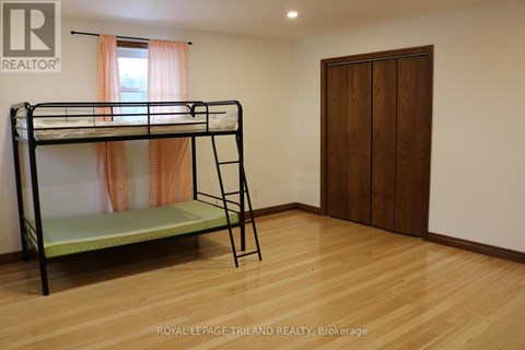 A bedroom with a bunk bed and a wooden door.