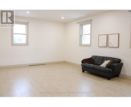 A living room with a couch and two pictures on the wall.