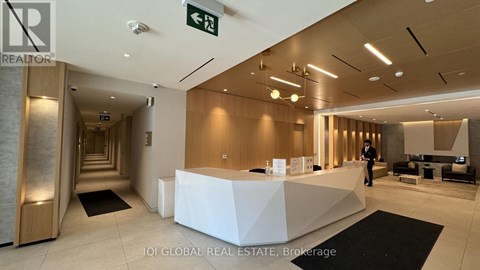 A reception area with a white desk and a person standing behind it.
