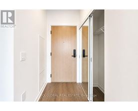 A hallway with a wooden door and a white wall.