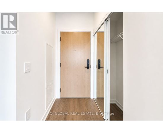 A hallway with a wooden door and a white wall.