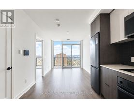 A modern kitchen with dark wood cabinets and a large window overlooking the city.