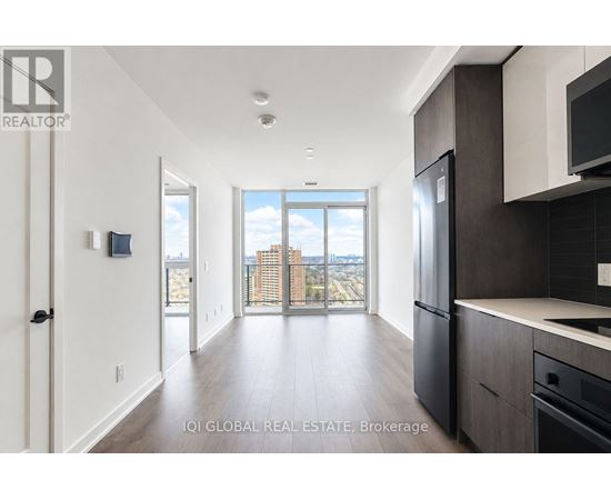 A modern kitchen with dark wood cabinets and a large window overlooking the city.