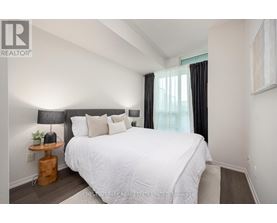 A bedroom with a white bed and a black headboard.