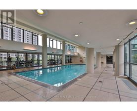 A large indoor swimming pool with a tiled floor and walls.