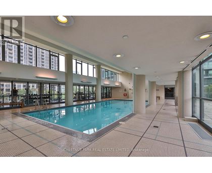 A large indoor swimming pool with a tiled floor and walls.