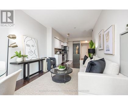 A living room with a white couch, a coffee table, and a painting on the wall.
