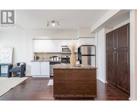 A modern kitchen with white cabinets and a wooden island.