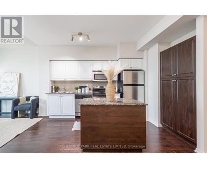 A modern kitchen with white cabinets and a wooden island.