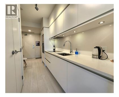 A modern kitchen with white cabinets and a sink.