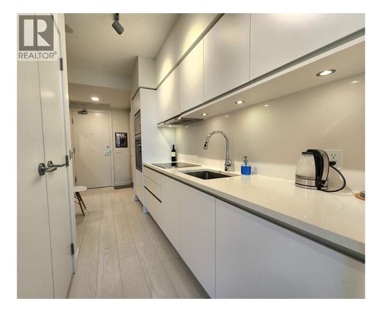 A modern kitchen with white cabinets and a sink.