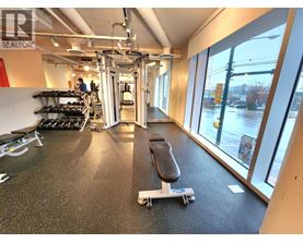 A gym with a black mat and a skateboard on it.