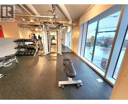 A gym with a black mat and a skateboard on it.