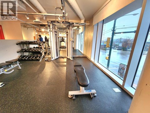 A gym with a black mat and a skateboard on it.