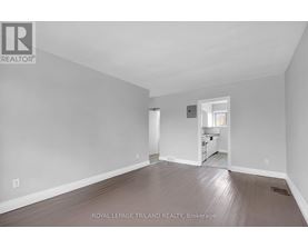 A large empty room with a doorway leading to another room.
