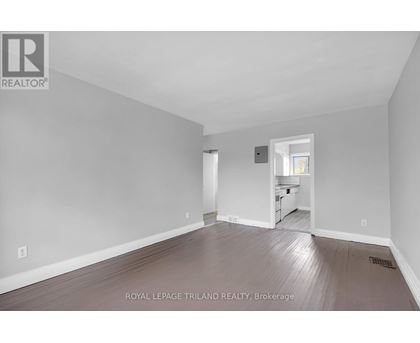 A large empty room with a doorway leading to another room.