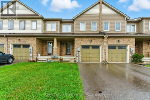 A large, well-maintained house with a car parked in the driveway.