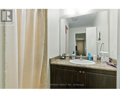 A bathroom with a sink, mirror, and shower curtain.
