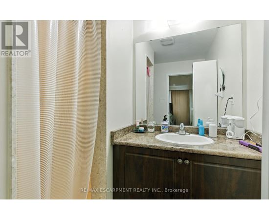 A bathroom with a sink, mirror, and shower curtain.