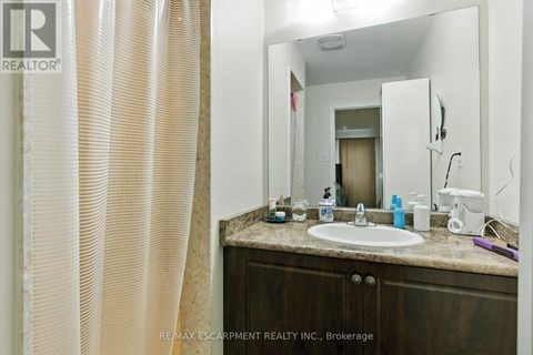 A bathroom with a sink, mirror, and shower curtain.