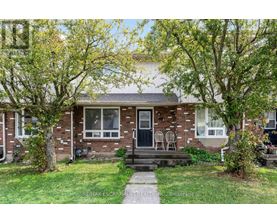 A house with a front yard and a tree in front of it.