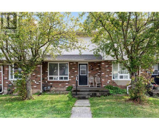 A house with a front yard and a tree in front of it.