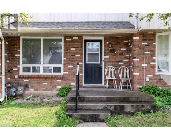 A house with a black door and two chairs on the porch.