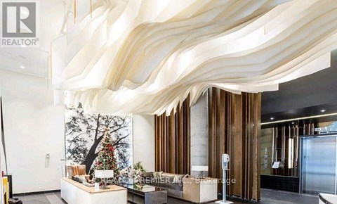 A modern interior space with a large, curved wooden structure overhead.