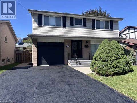 A house with a garage and a driveway in front.