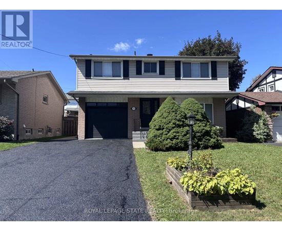 A house with a garage and a driveway in front of it.