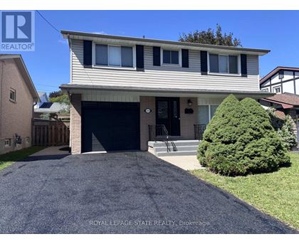 A house with a garage and a driveway in front of it.