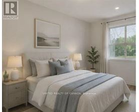 A bedroom with a bed, nightstands, and a framed picture on the wall.